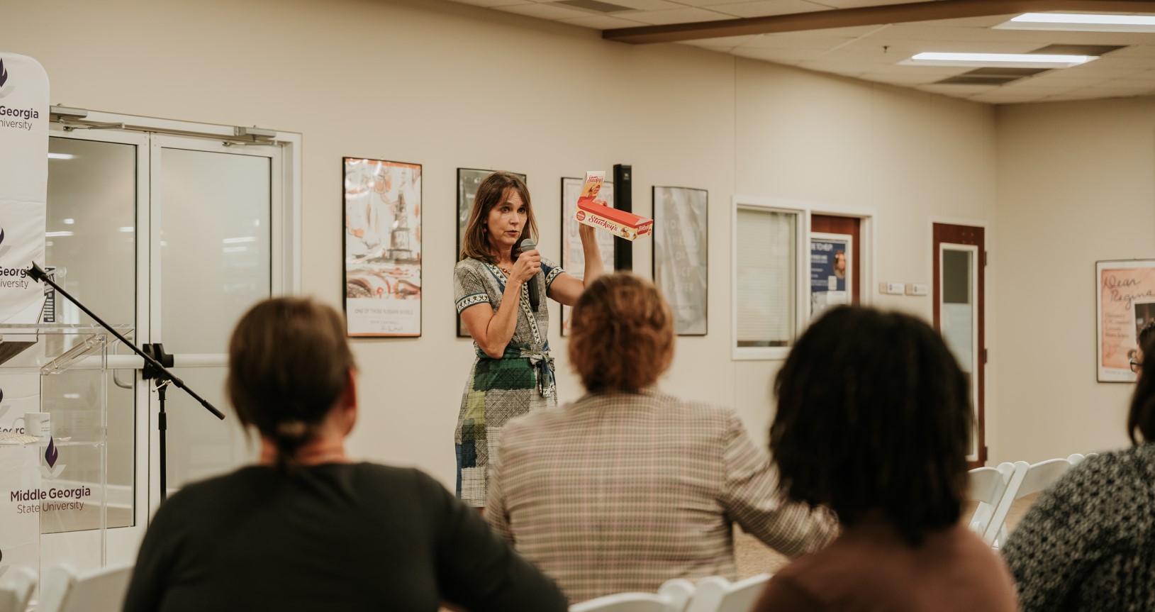 stephanie stuckey holding up an empty box of stuckey's pecan rolls to demonstrate for the student q and a